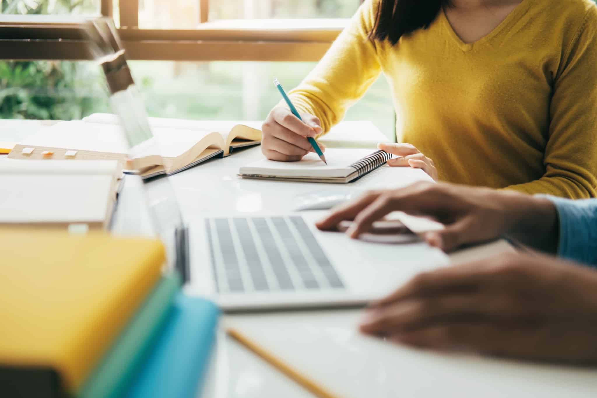 jovem mulher estudante e colega, alunos do ensino superior, estudam e consa