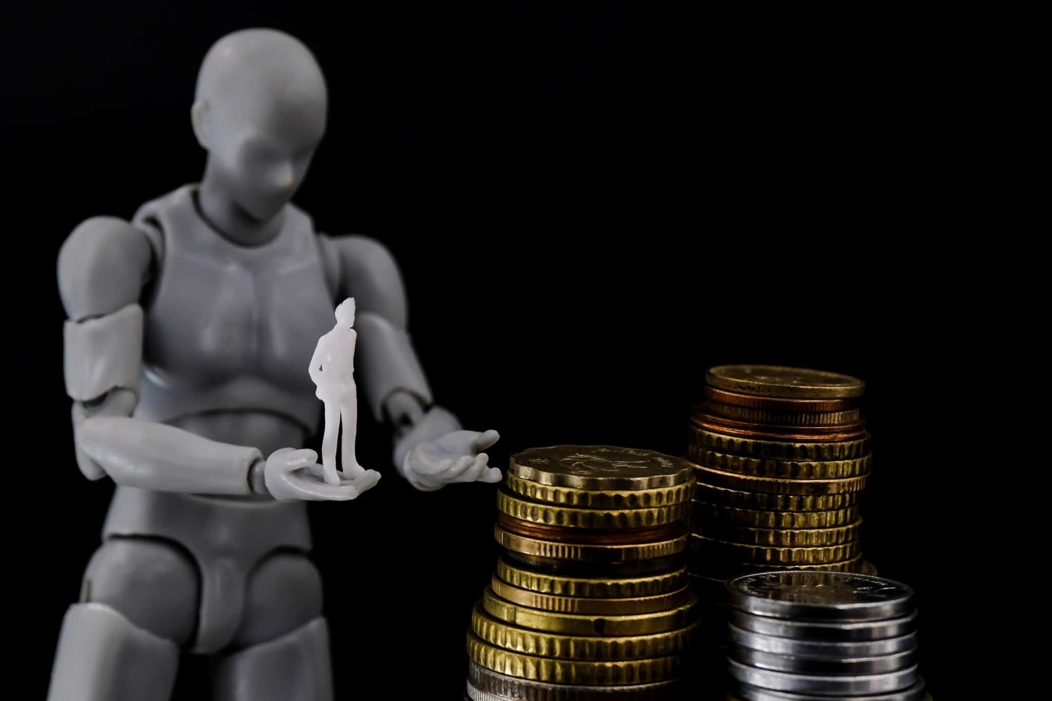 Uma imagem de um robô com um boneco de figura humana na mão e moedas amontoadas na sua frente