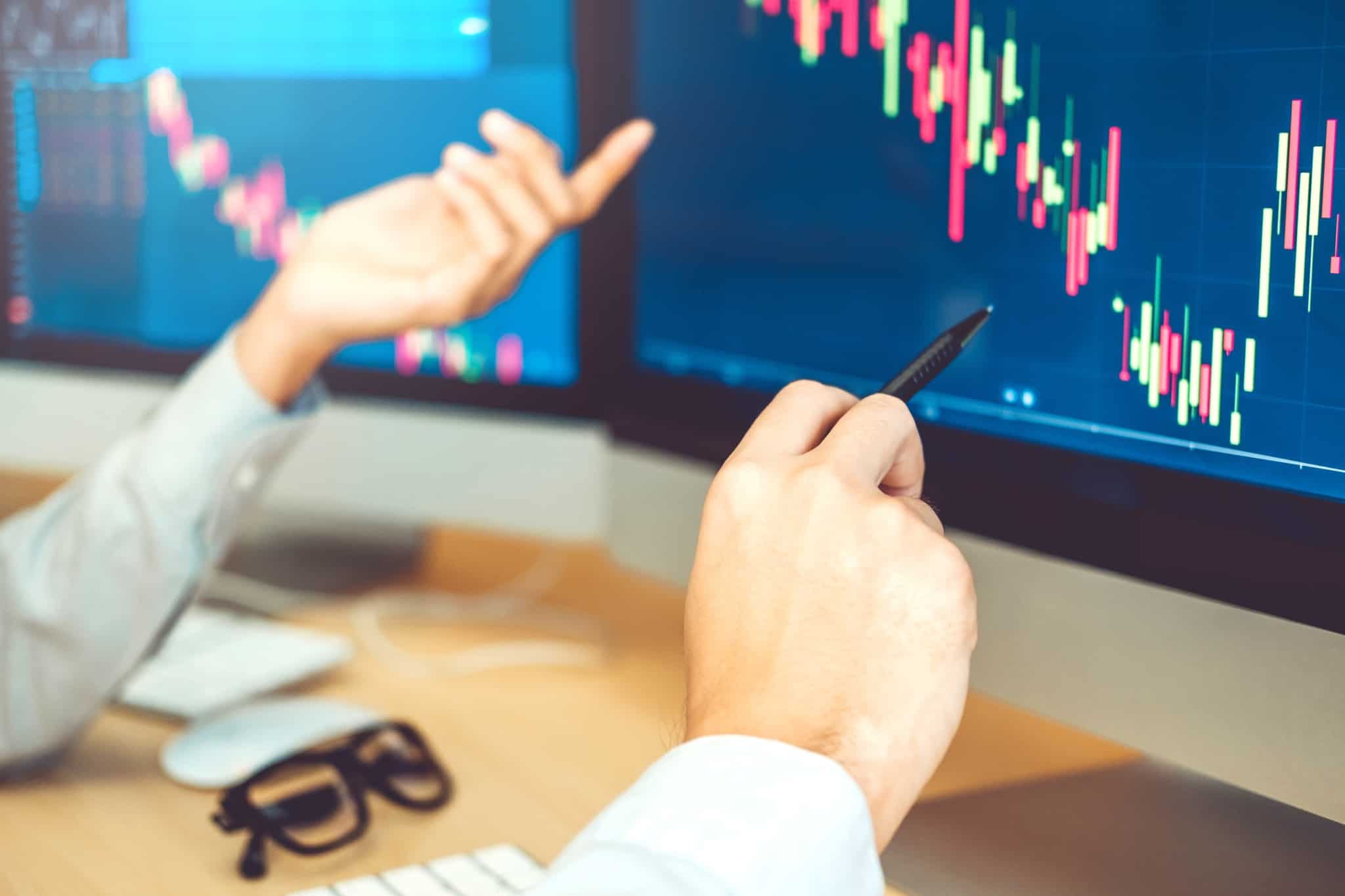 investidor a olhar para ecrã com gráfico demonstrando a evolução do preço das ações