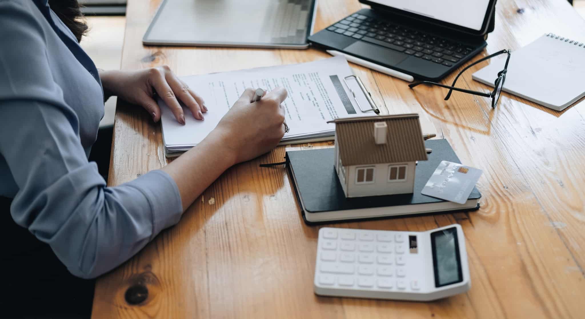 agente imobiliário a assinar um documento para aprovação do crédito habitação