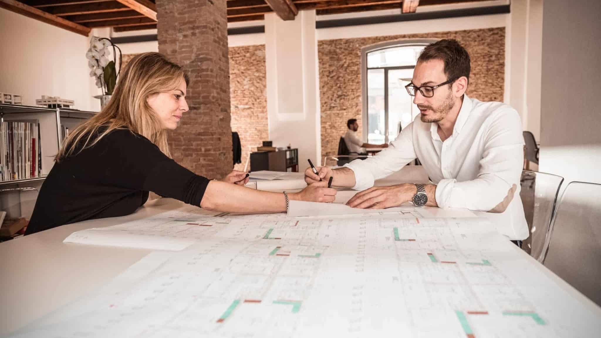 dois arquitectos a trabalhar num projecto em cima de uma mesa