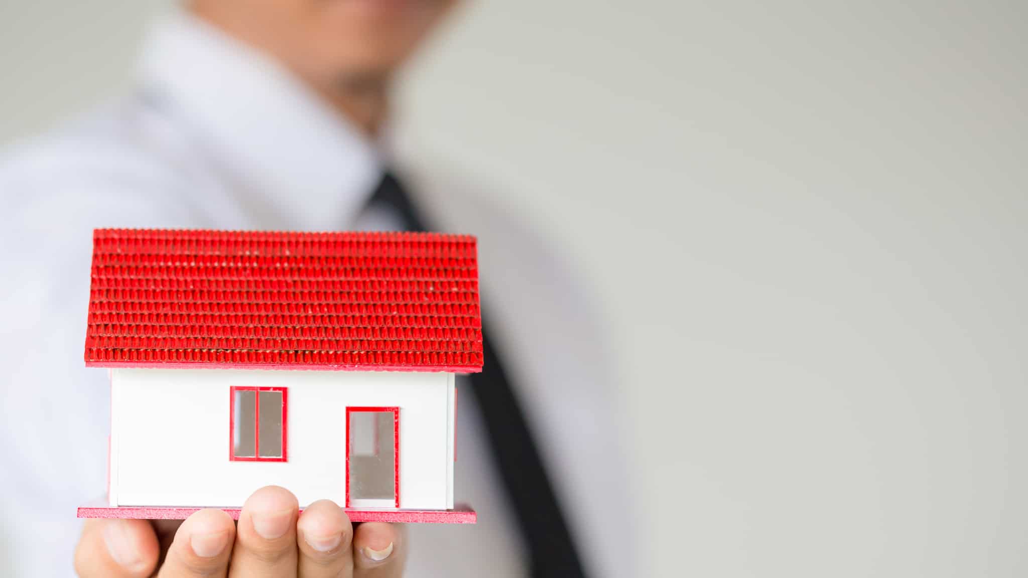 maquete de casa na mão de um homem