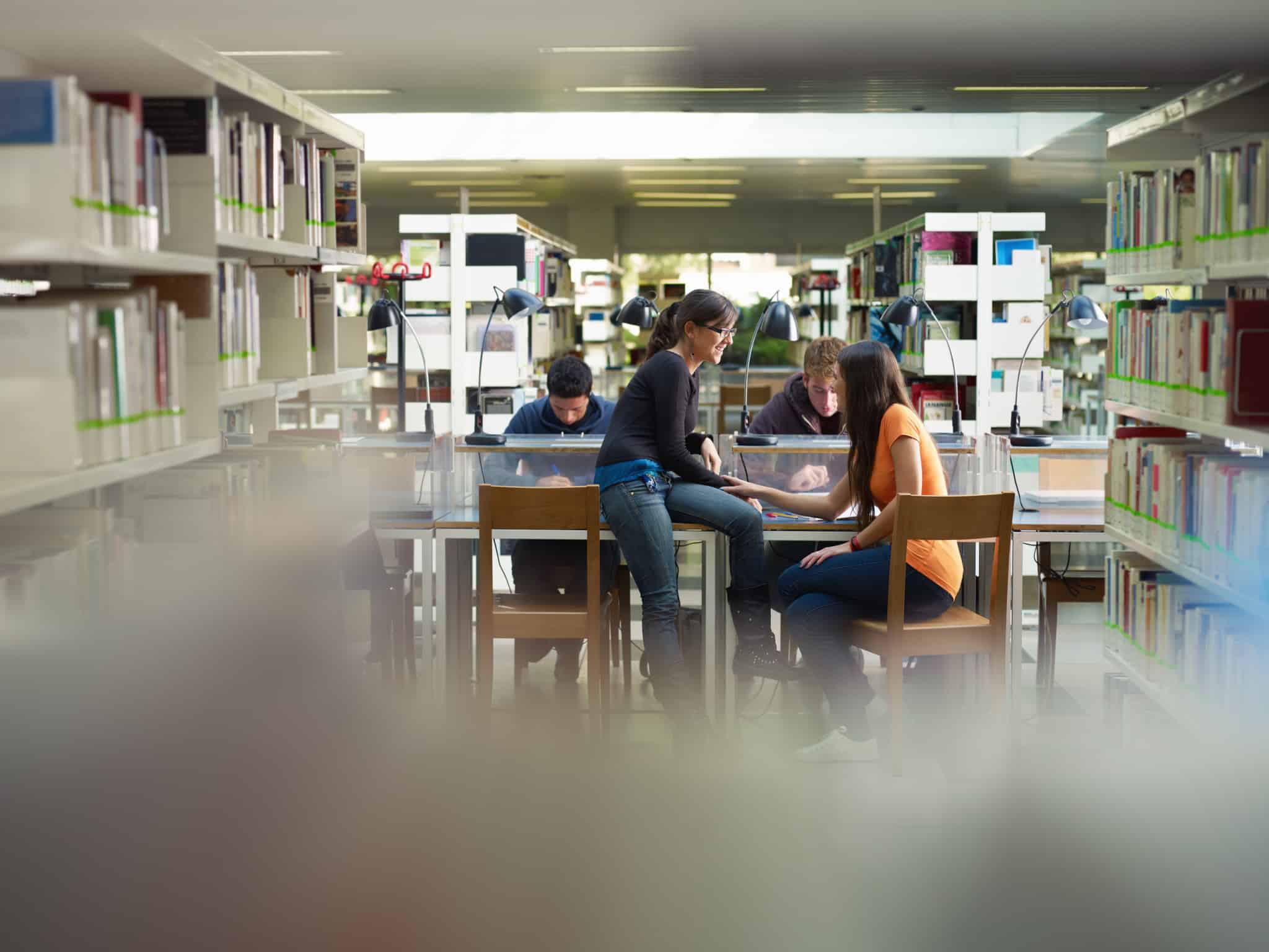 grupode jovens estudantes universitários, no ambiente de uma biblioteca, ilustram a decisão de estudar no interior de Portugal e os apoios que existem