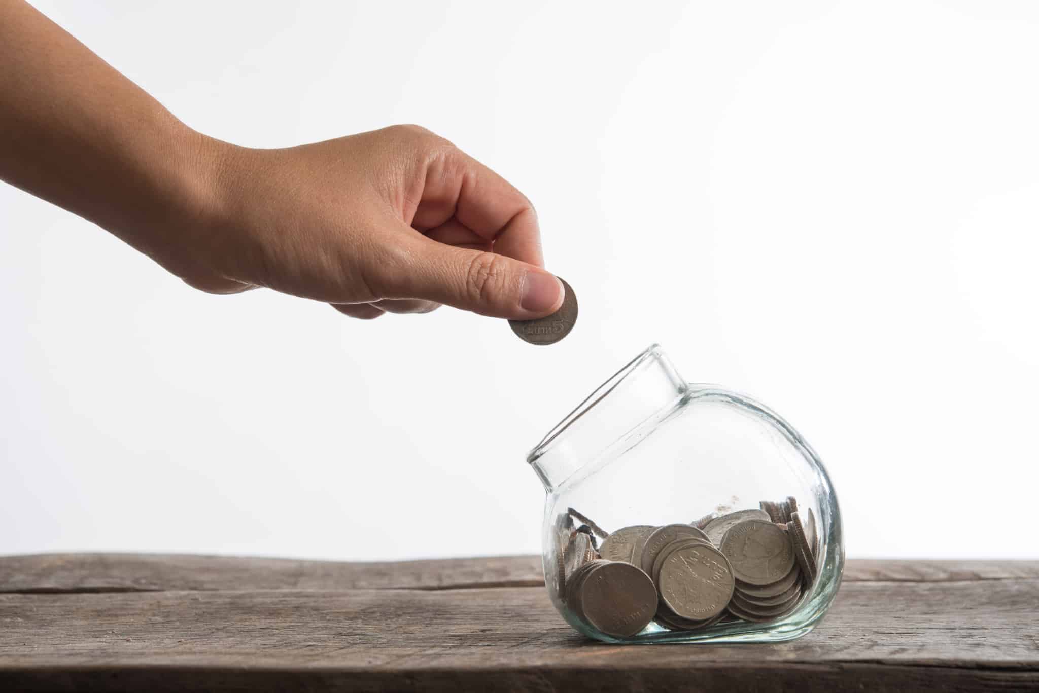 mão de um homem a juntar dinheiro para investir num PPR
