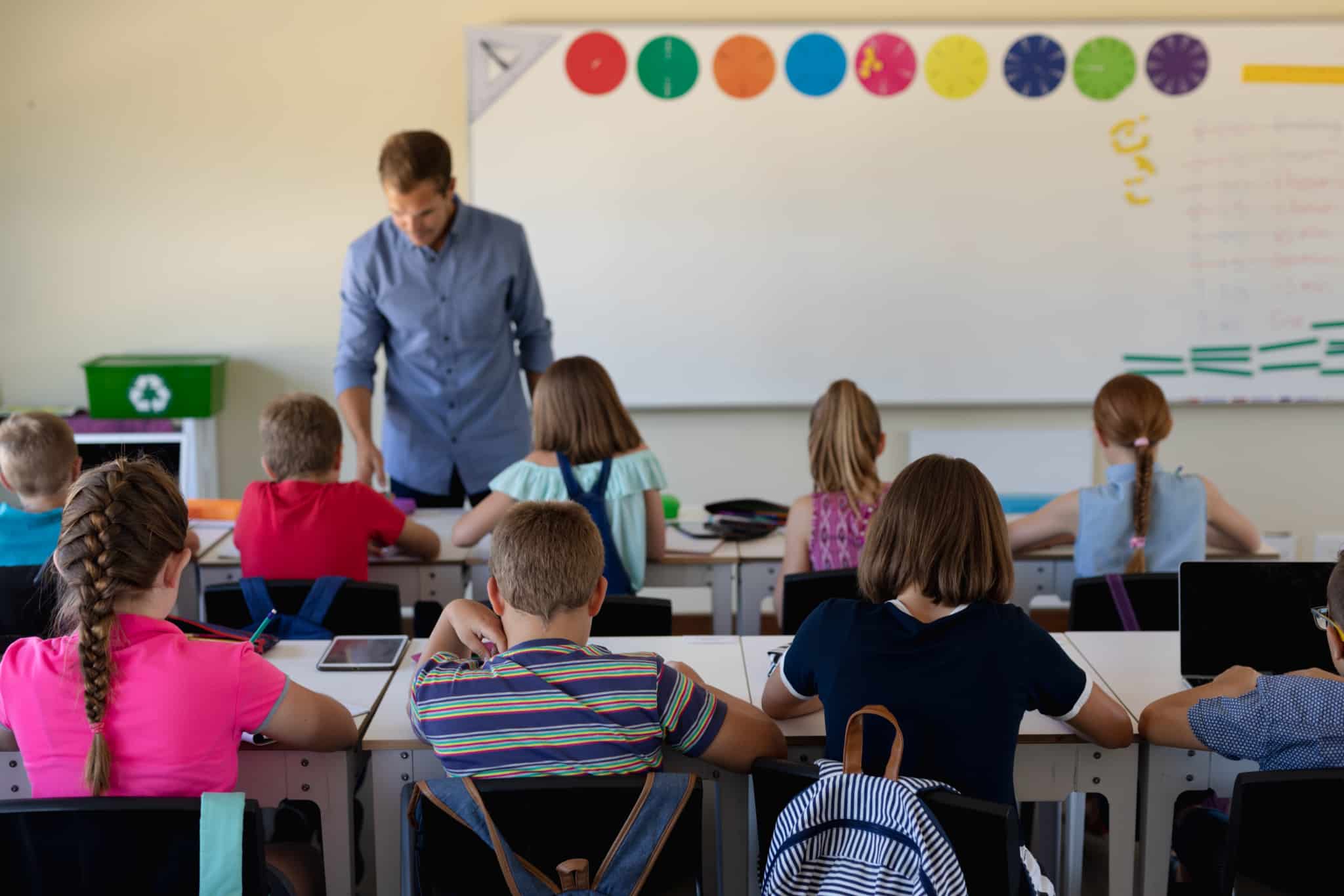 sala de aulas com crianças, estudantes que precisam de fazer prova escolar, atentos ao professor que dá a aula