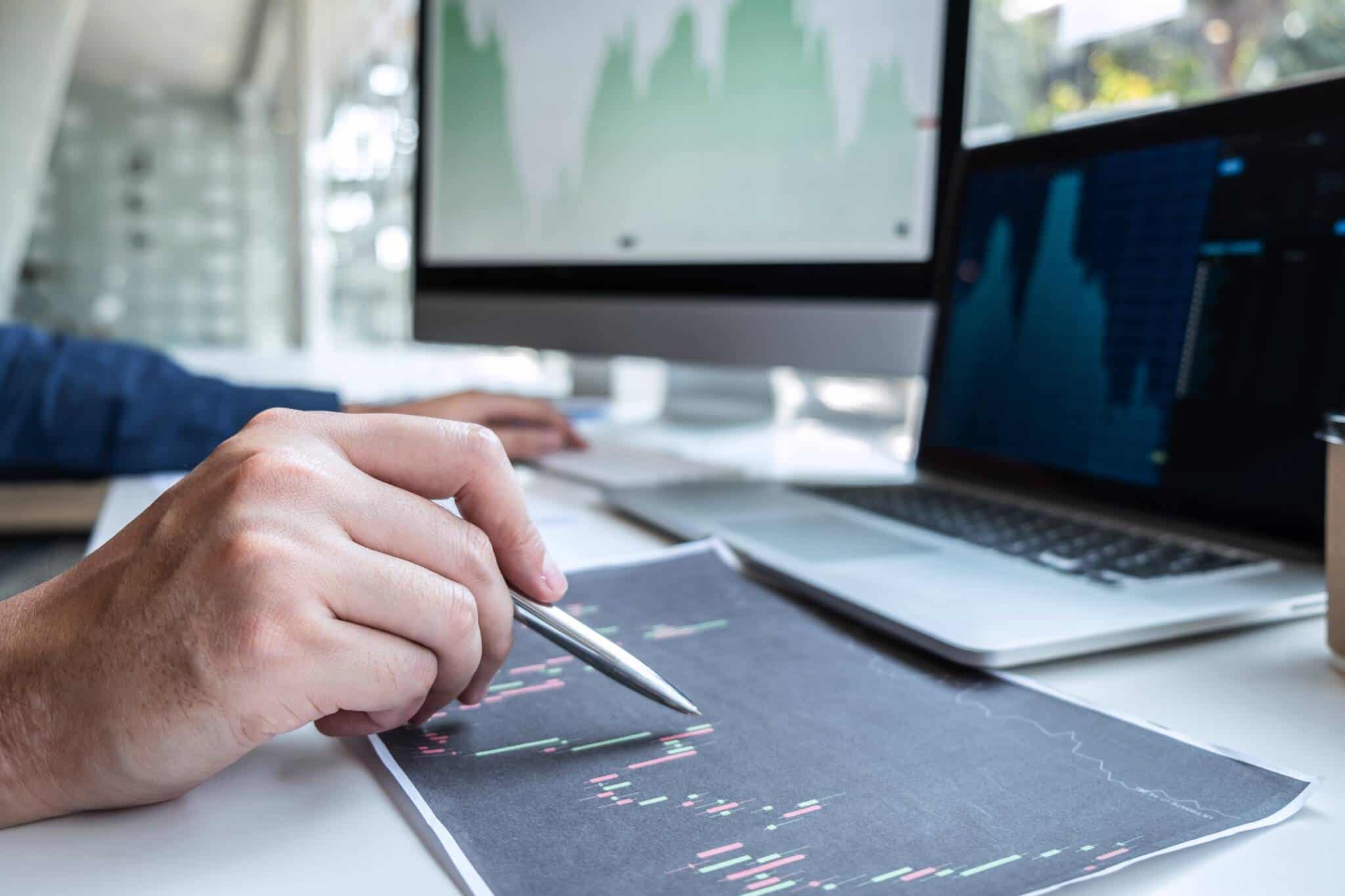 investidor a analisar gráficos com a evolução dos mercados