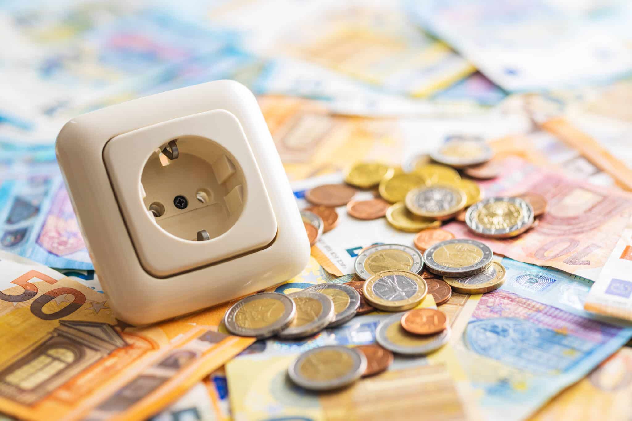 em cima de um monte de notas variadas de Euro está uma ficha elétrica ilustrando a eletricidade mais cara a partir de janeiro