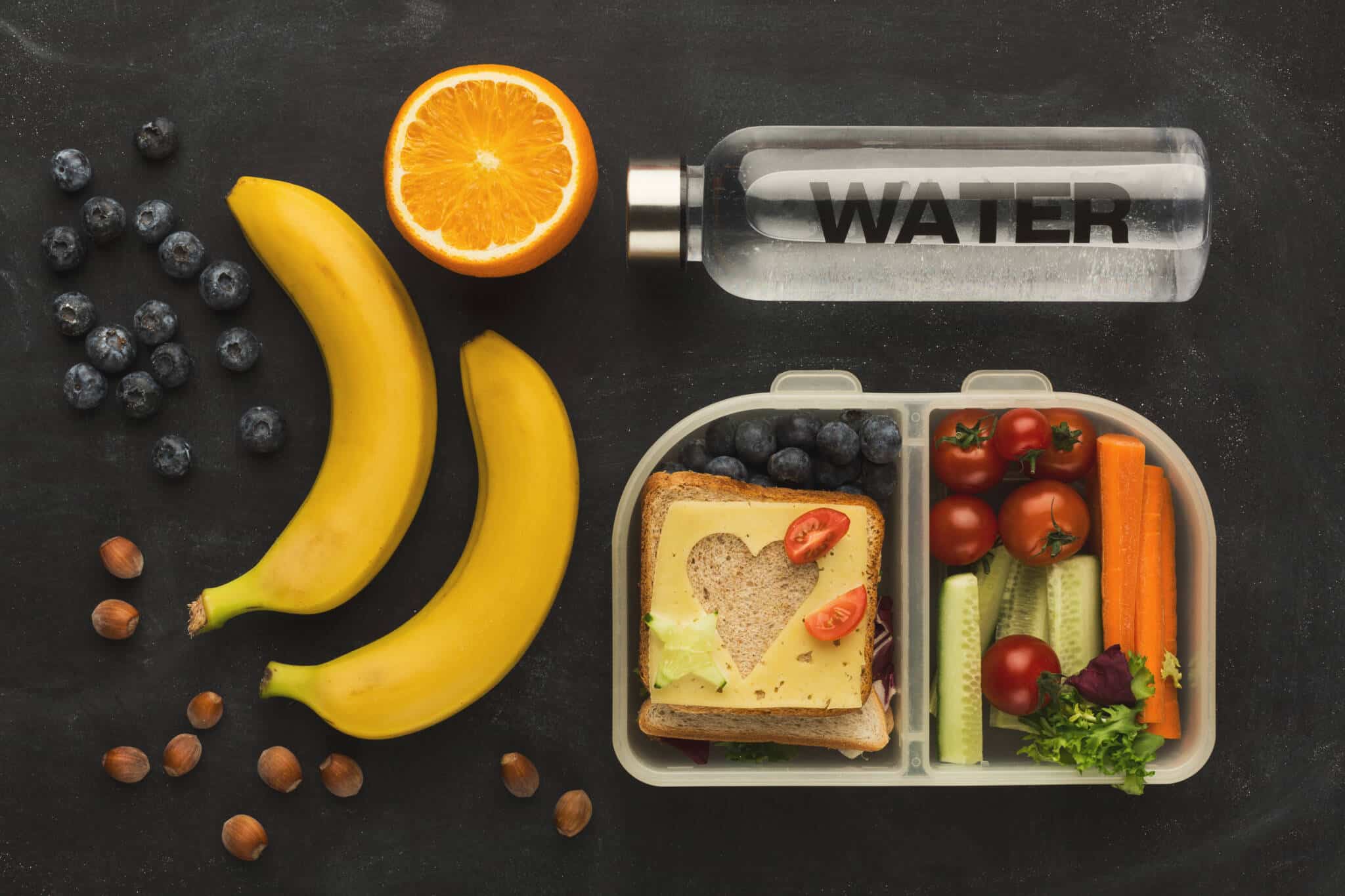 mesa com um grupo de alimentos saudáveis, dos amis variados e coloridos, ilustram as diferentes soluções para fazer lanches nutritivos e económicos para as crianças