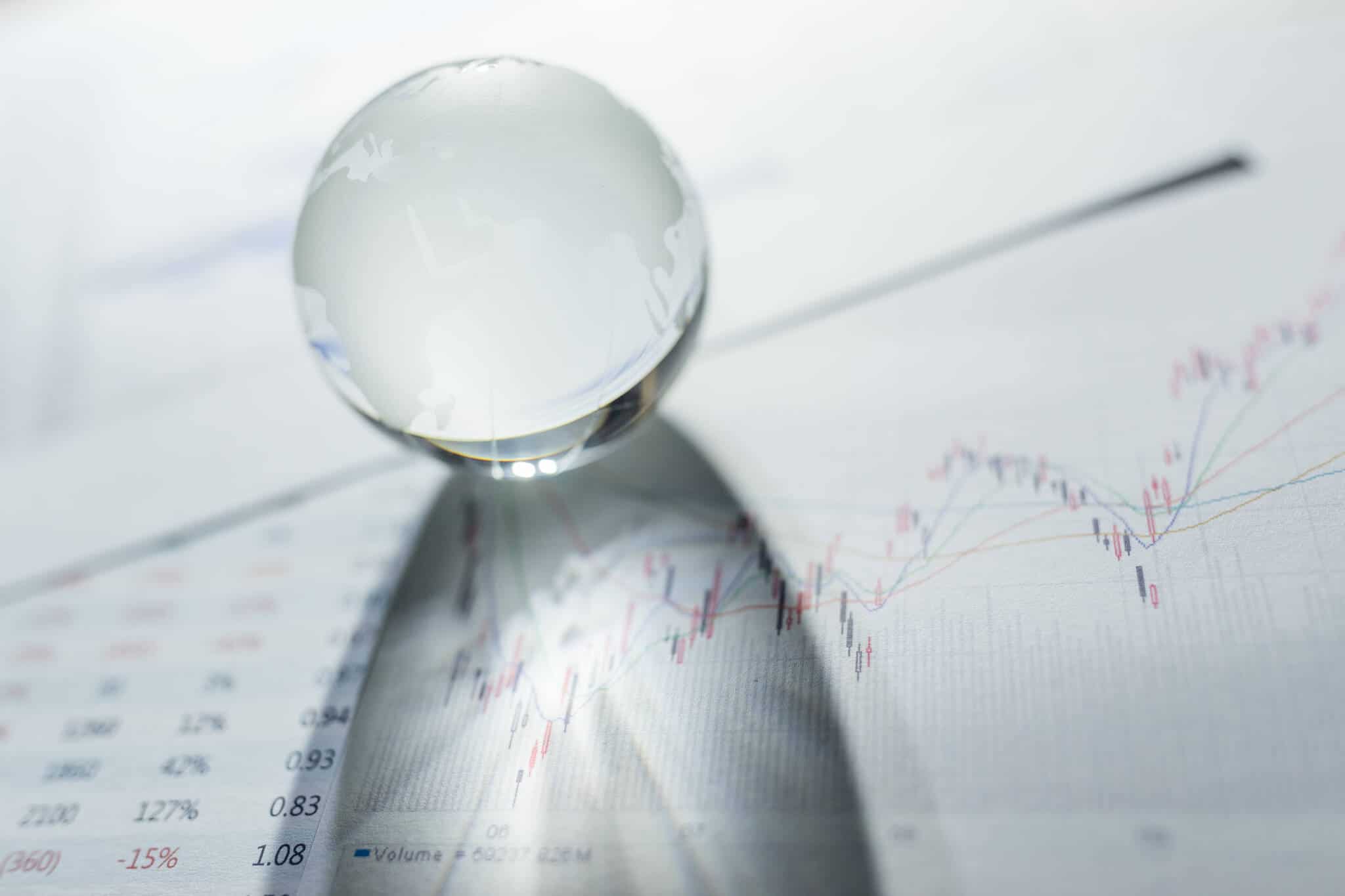 bola de cristal a rolar sobre documentos financeiros, com números e gráficos, ilustram a diferença que pode fazer pensar como um economista