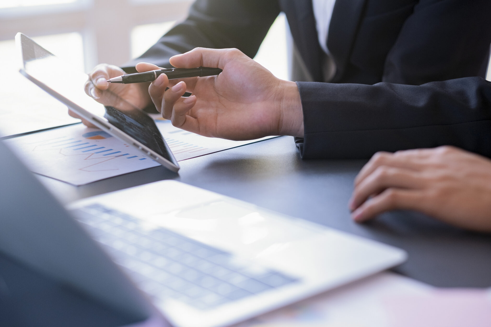 Investidores a analisar desempenho dos investimentos num ipad e computador