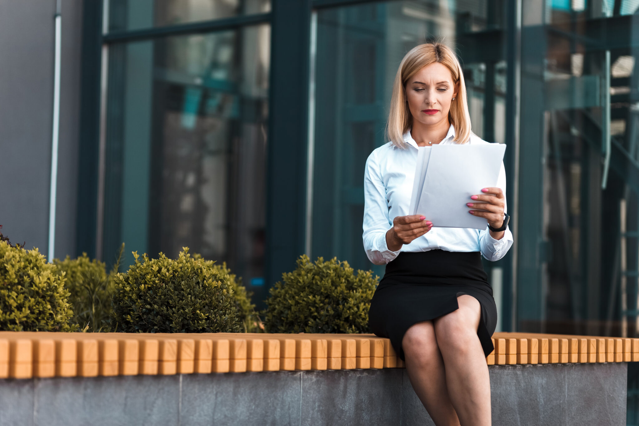 mulher sentada no exterior da empresa a ler o certificado de trabalho