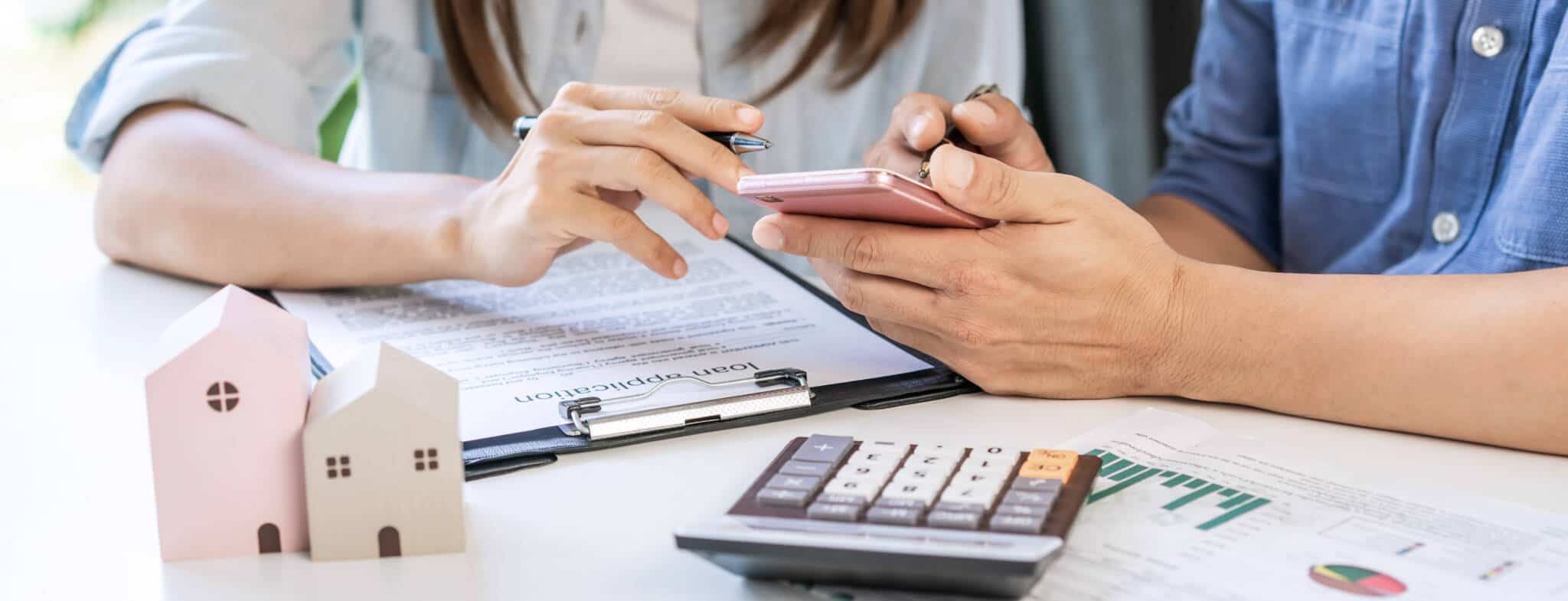 casal a olhar para o seu crédito habitação e calculando a sua taxa de esforço