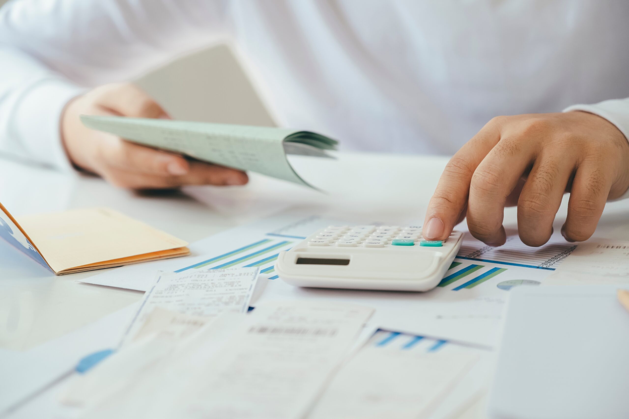 Fechar atividade nas Finanças ilustrado com ãos de jovem a fazer calculos na calculadora