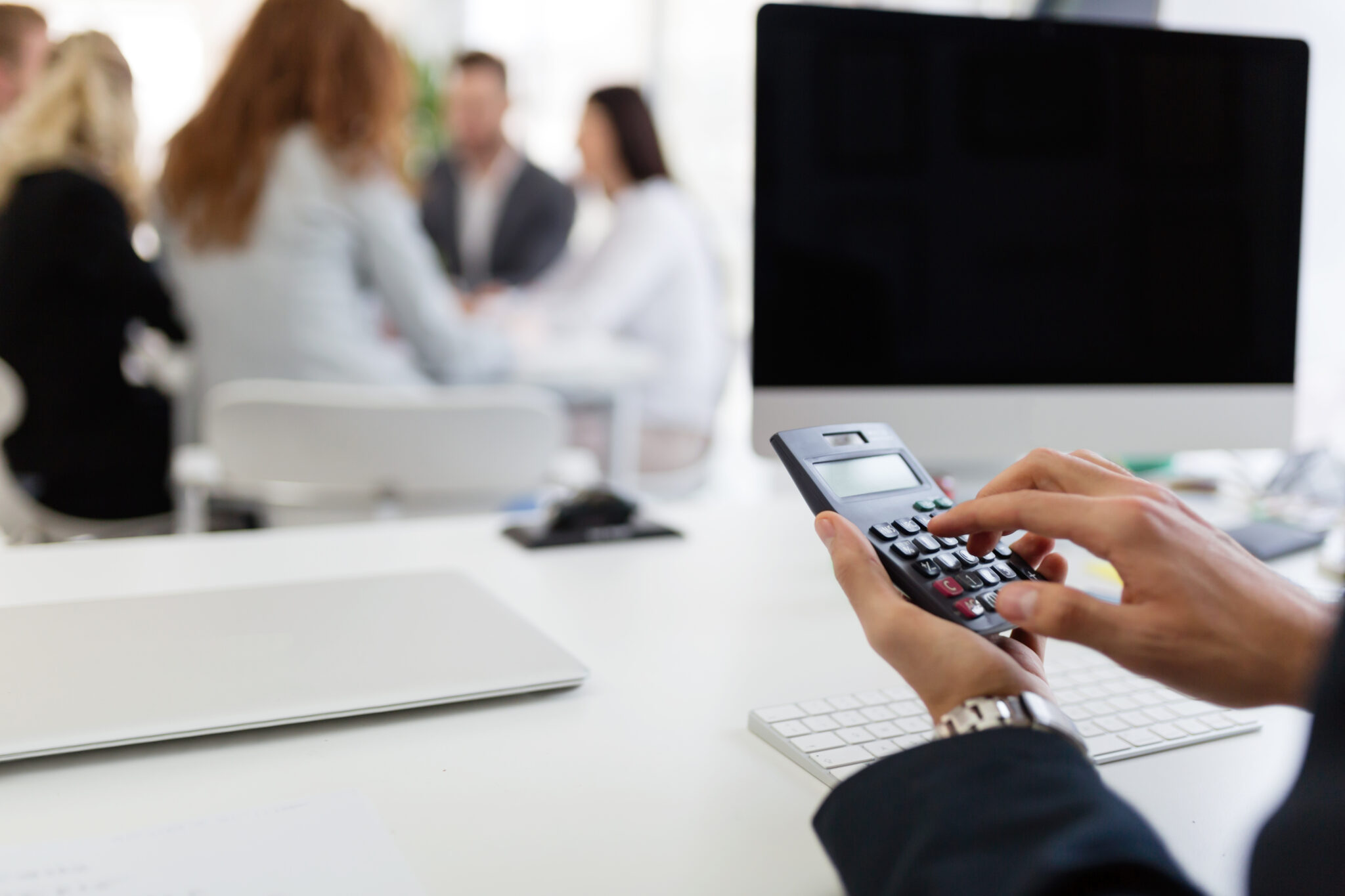 pessoa a calcular a alteração nos seus rendimentos em 2023 com uma calculadora
