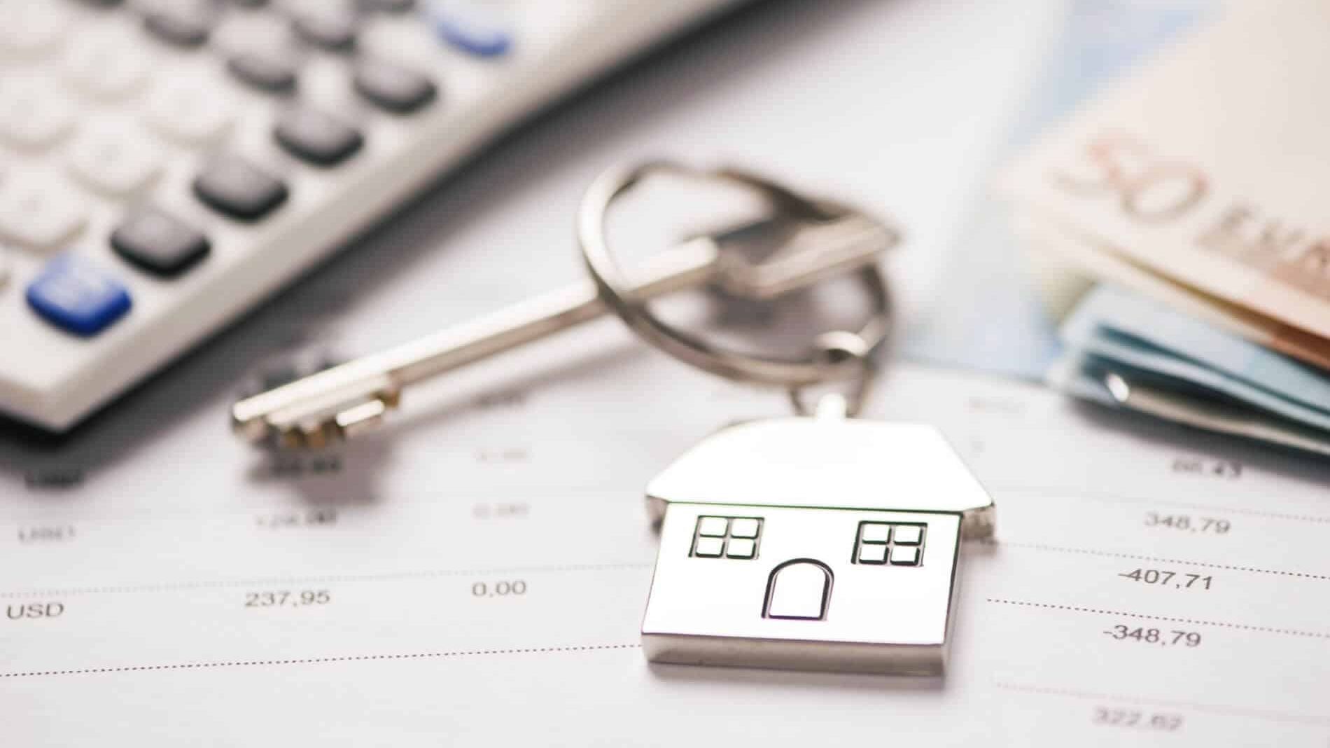 porta-chaves e calculadora que representam os custos durante as várias fases de um crédito habitação
