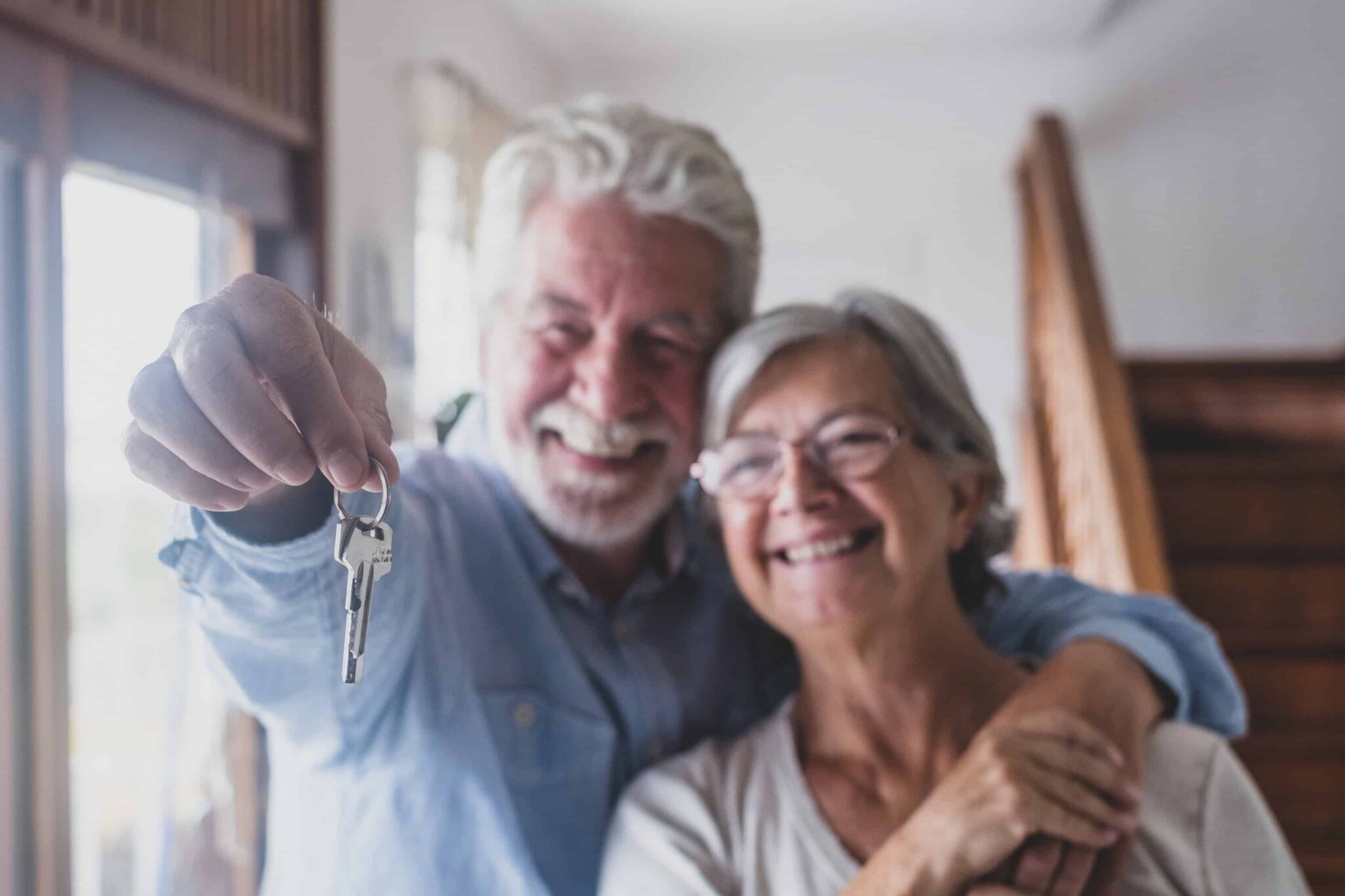 Casal em idade avançada a segurar chave depois de comprar casa com crédito habitação