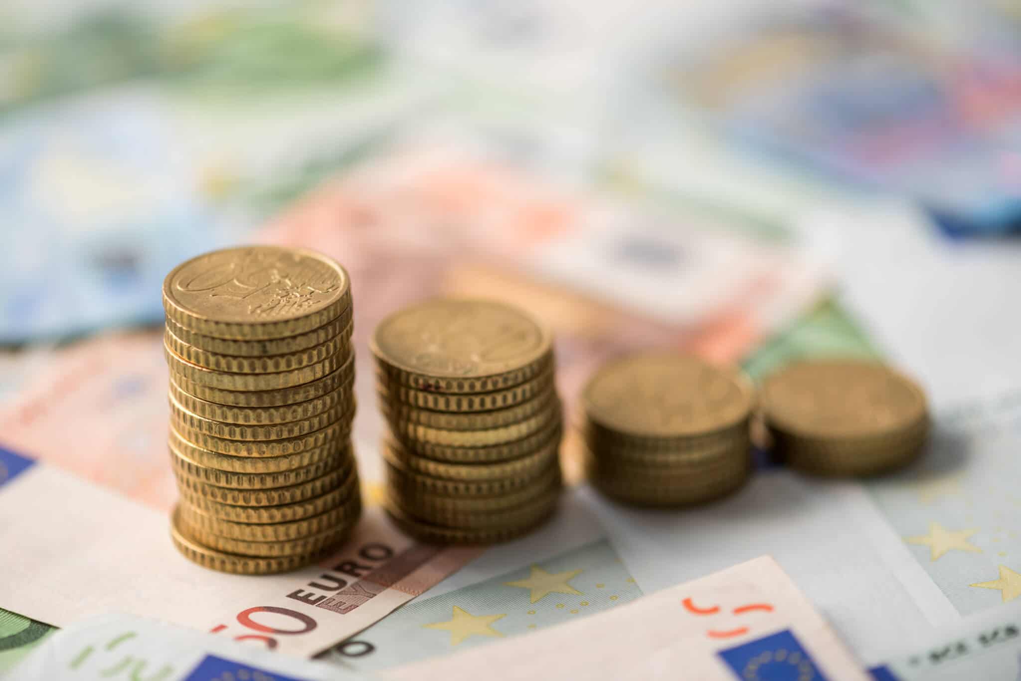 pilhas de moedas de euro sobre notas