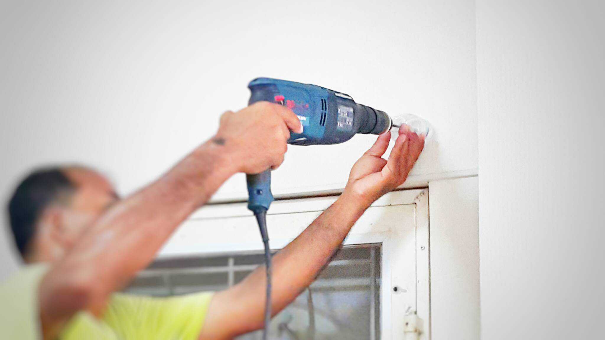 Homem a trocar janelas para eficientes simbolizando valorizar casa com obras