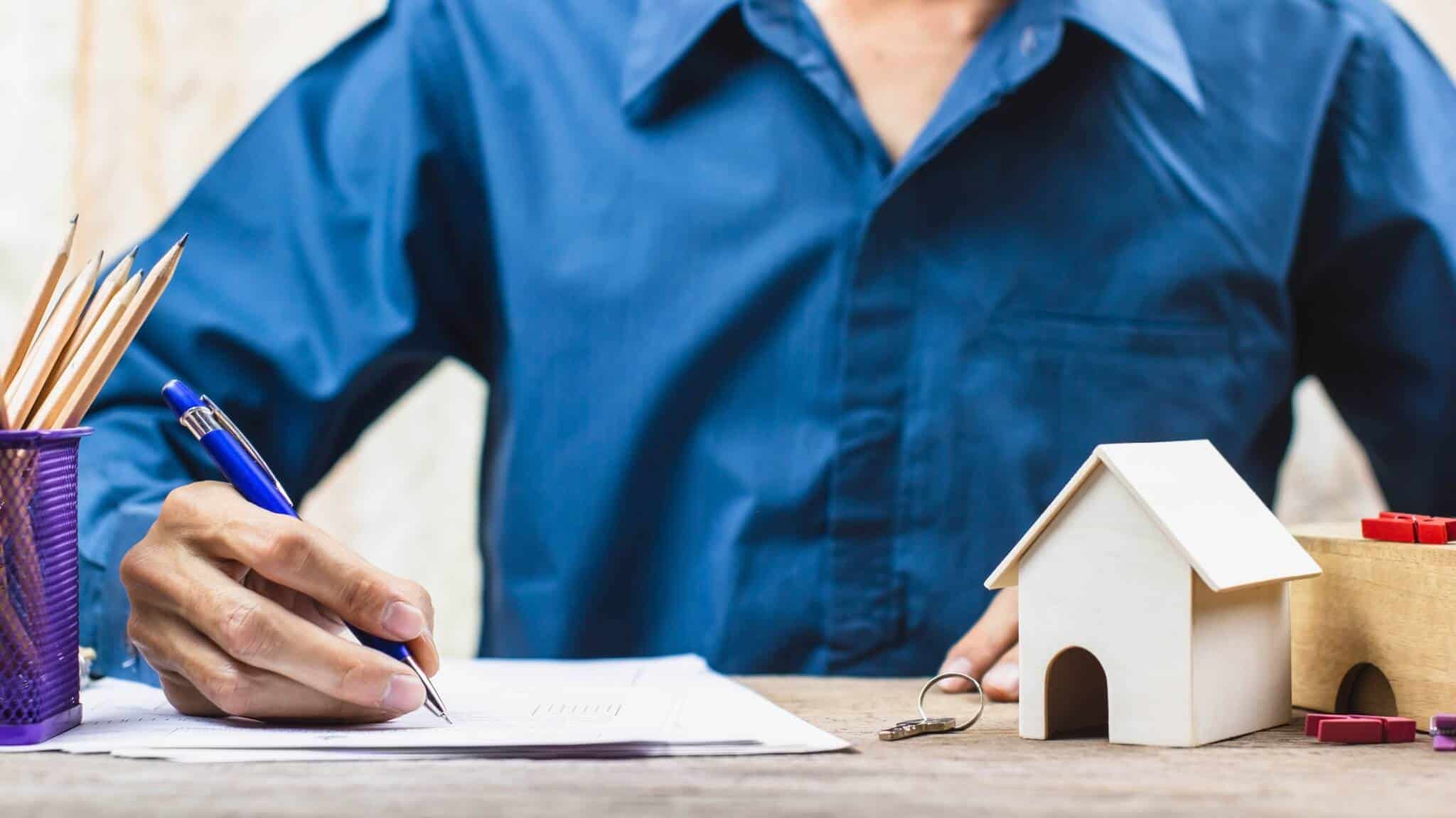 Homem a assinar contrato de crédito habitação