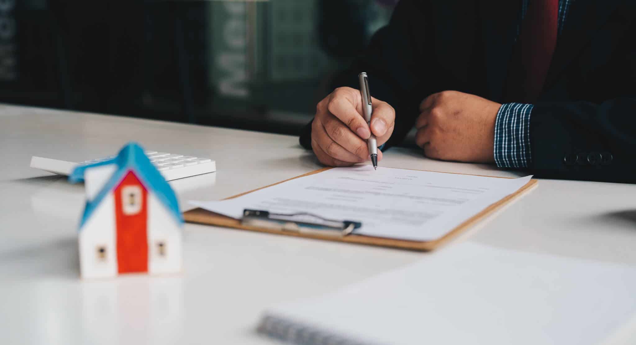 Pessoa a assinar depois de saber o que deve constar num contrato com uma imobiliária