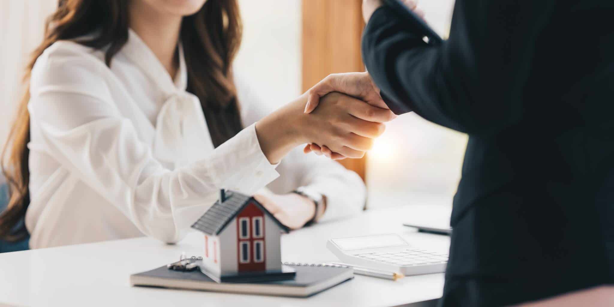 gente imobiliário a apertar a mão de cliente