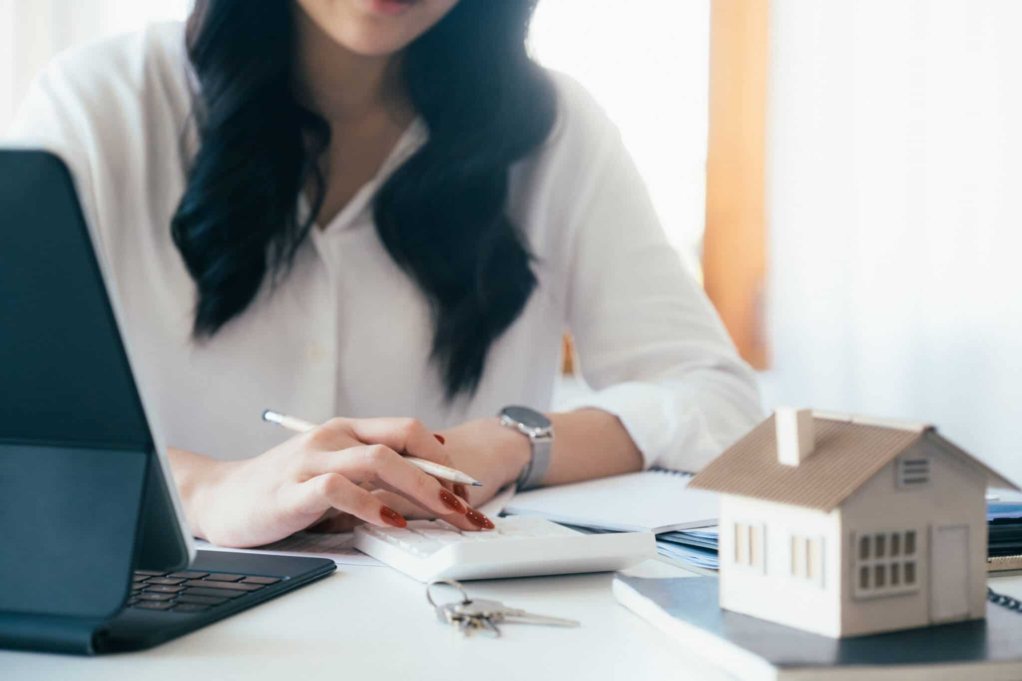mulher a fazer o cálculo das mais-valias que vai pagar após vender a sua casa