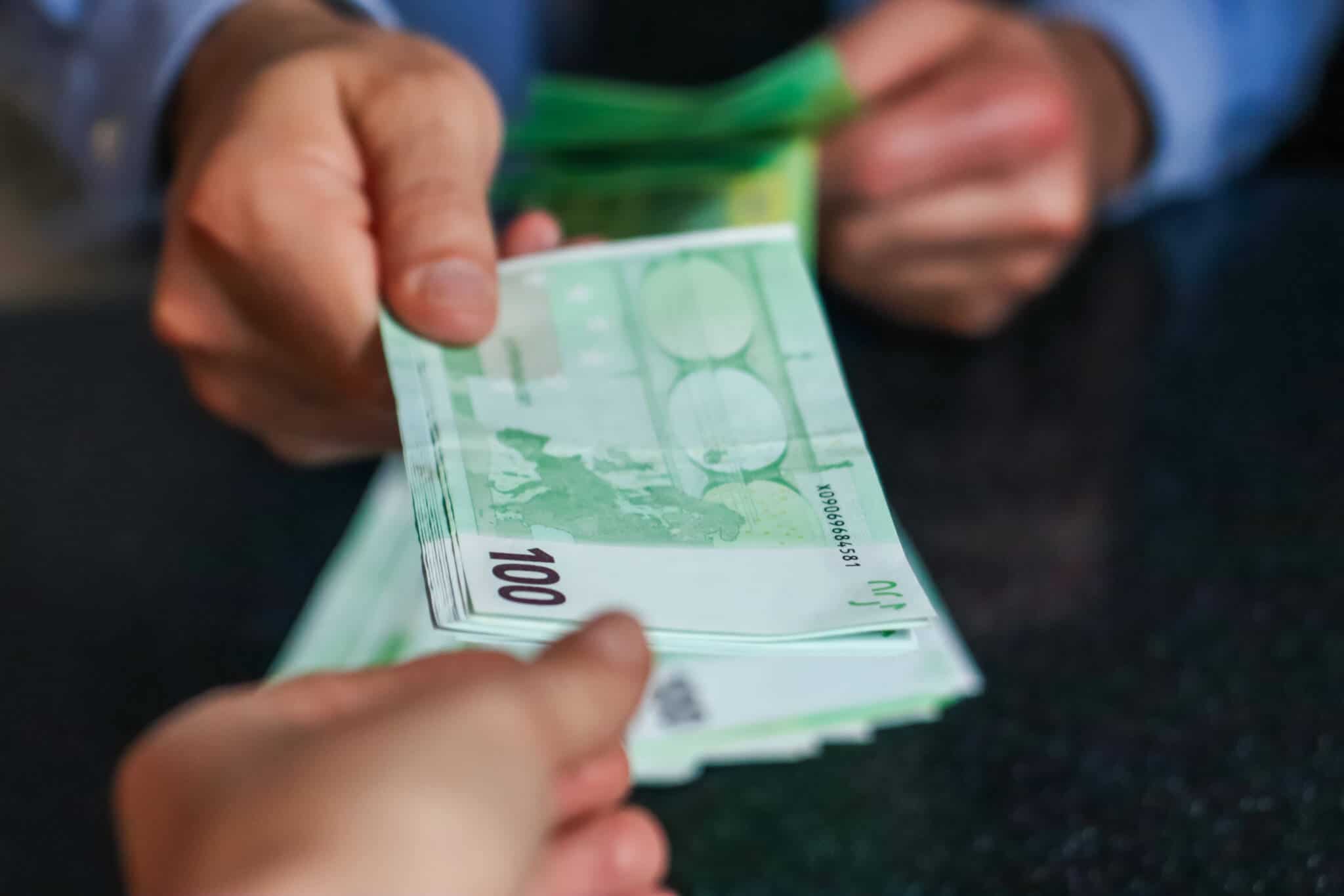 pessoa a segurar notas de 100 euros