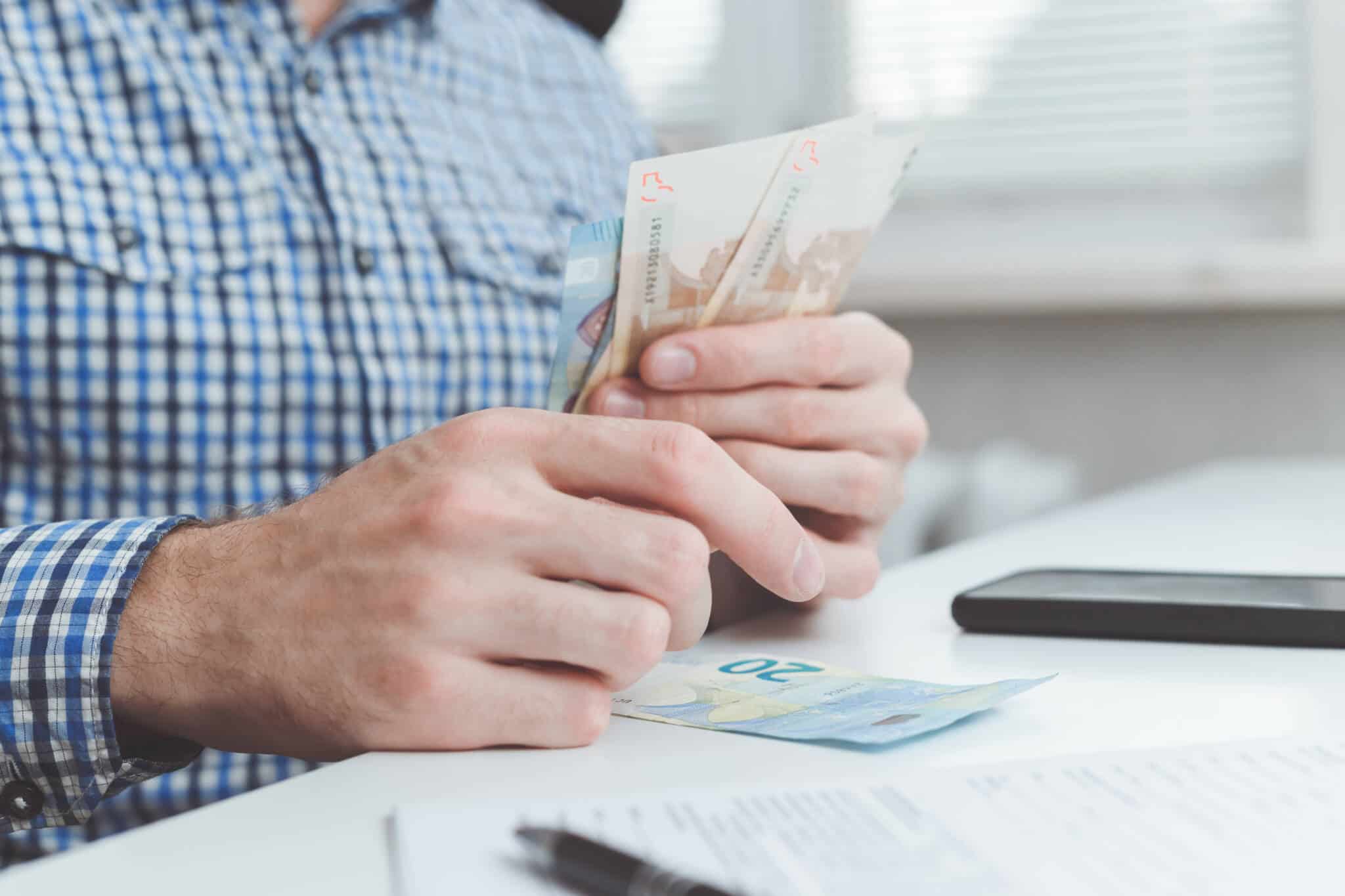homem a fazer contas à diferença de rendimentos do primeiro para o segundo semestre em 2023