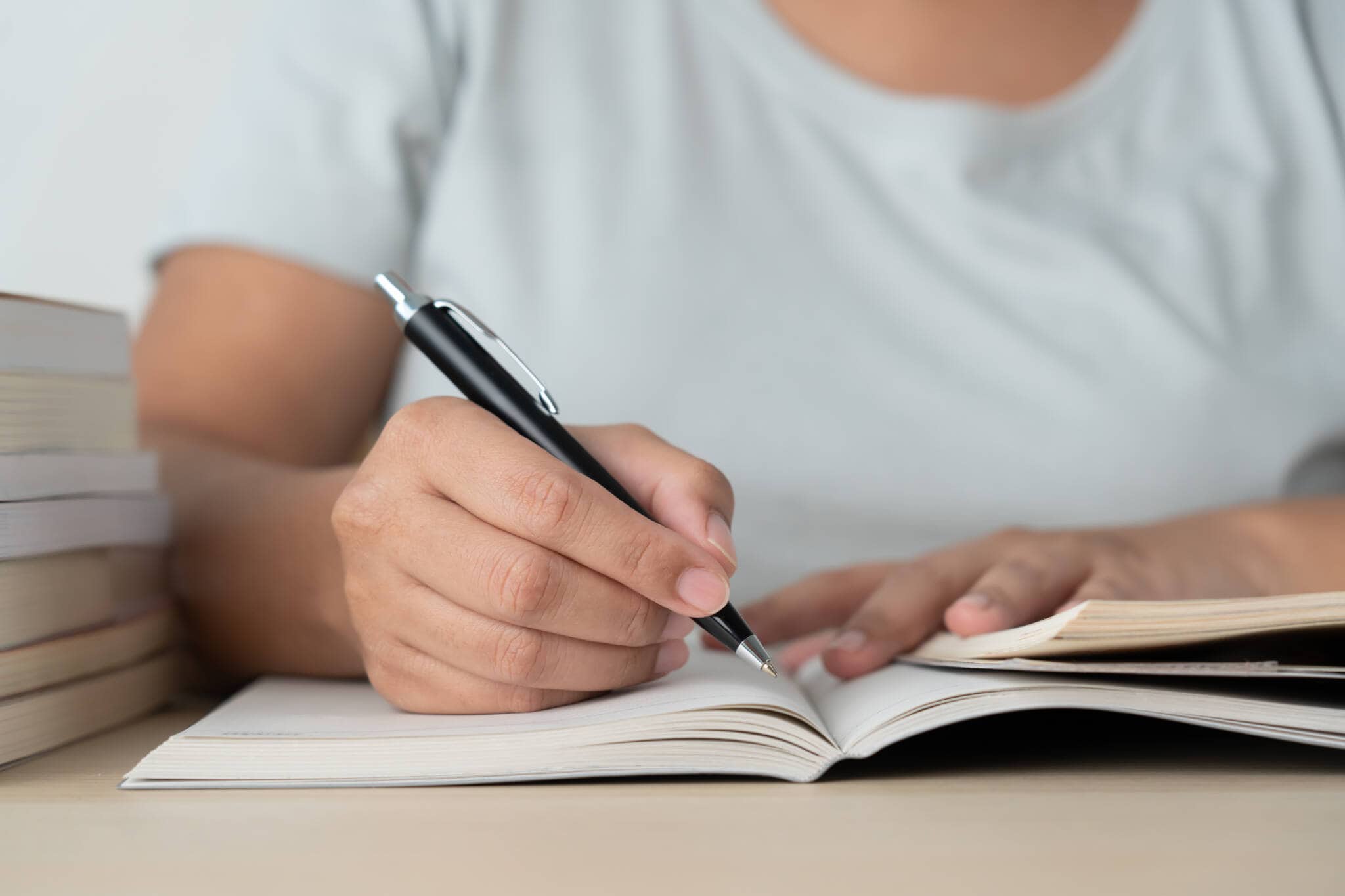 pessoa a escrever num caderno