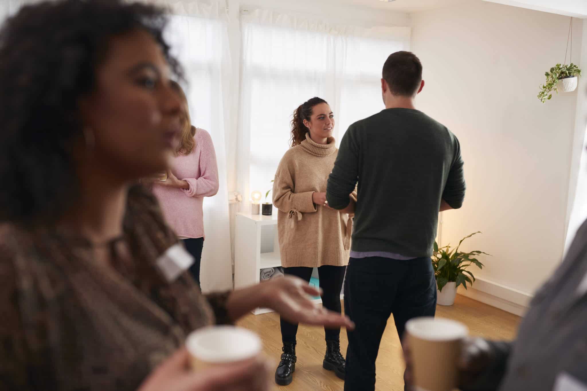 grupo de vizinhos, homens e mulheres, nuam sala a conversar com o Administrador de condomínio