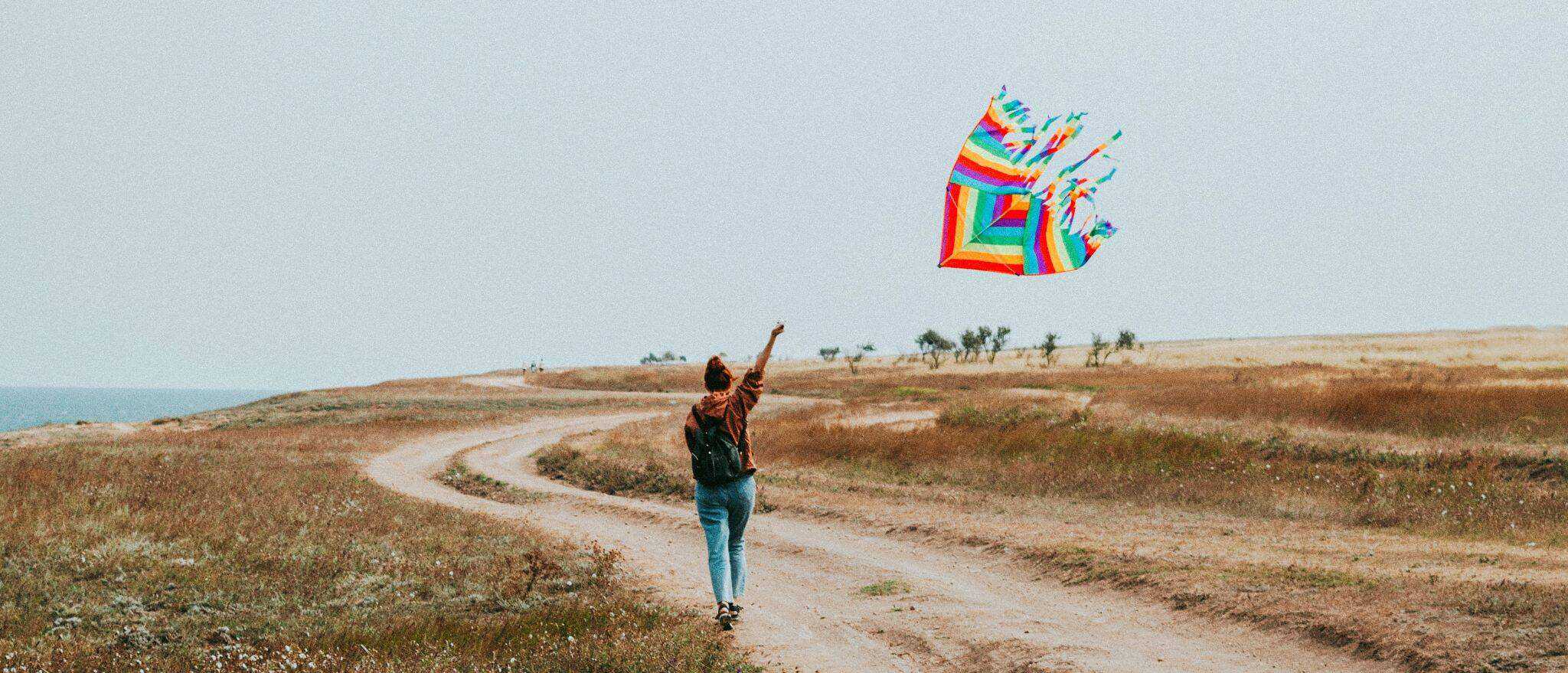 mulher a andar ao ar livre com papagaio de papel na mão