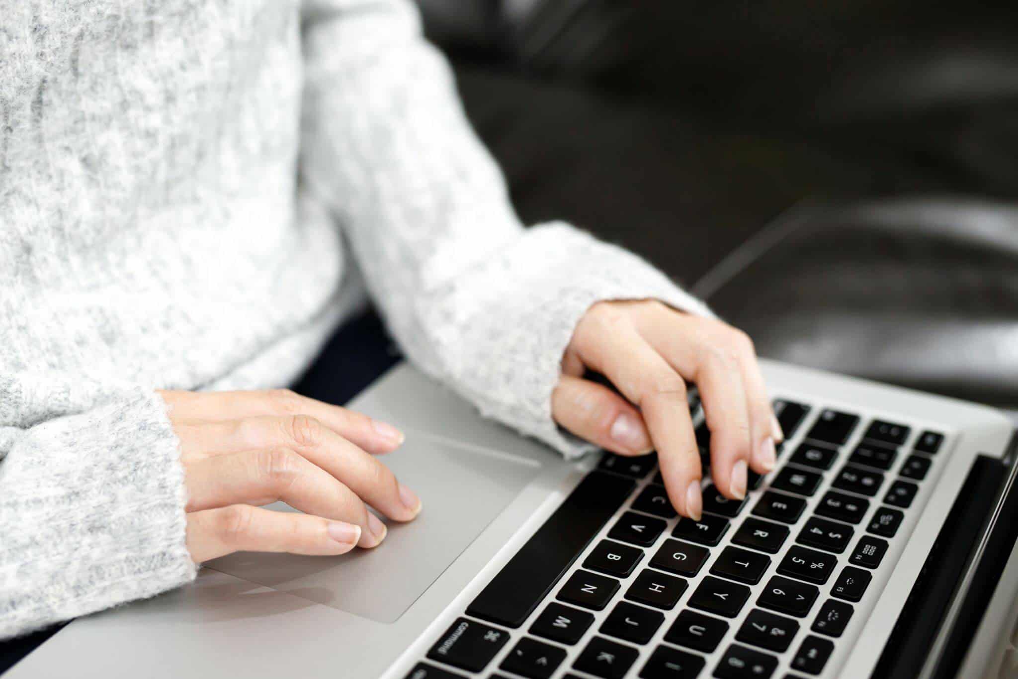 Mãos de uma mulher a mexer em computador