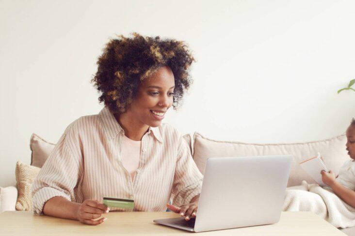 Mulher feliz porque está ao computador a poupar nos seus créditos