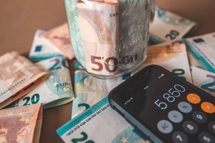 notas de 20 e 50 euros e telemóvel com a calculadora aberta