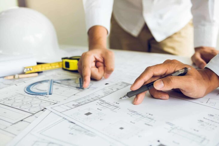 imagem de uma projeto de obras - planta de uma casa - duas pessoas a apontar para o projeto