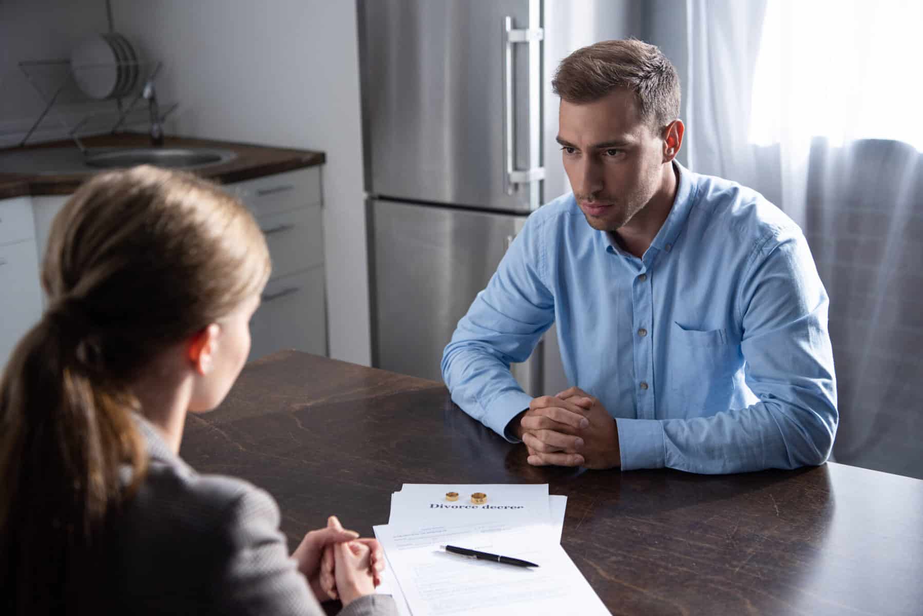 casal sentado à mesa a oficializar acordos para dar seguimento ao seu divórcio amigável