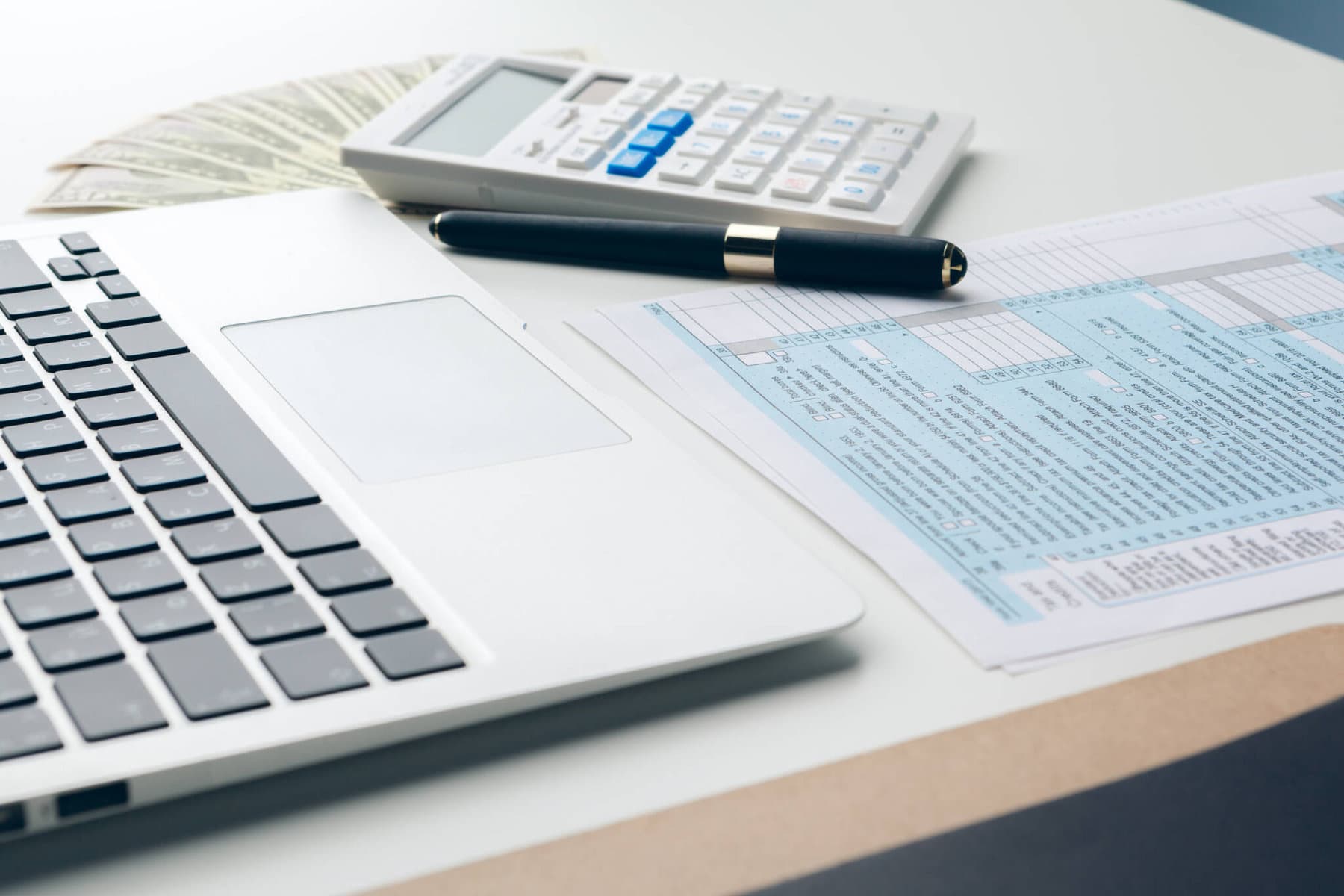 teclado de um computador portátil junto a uma calculadora a ilustrar o apuramento dos escalões de IRS para 2018