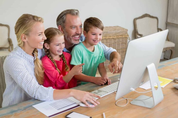 casal com os dois filhos frente ao computador a atualizar o agregado familiar no portal das finanças