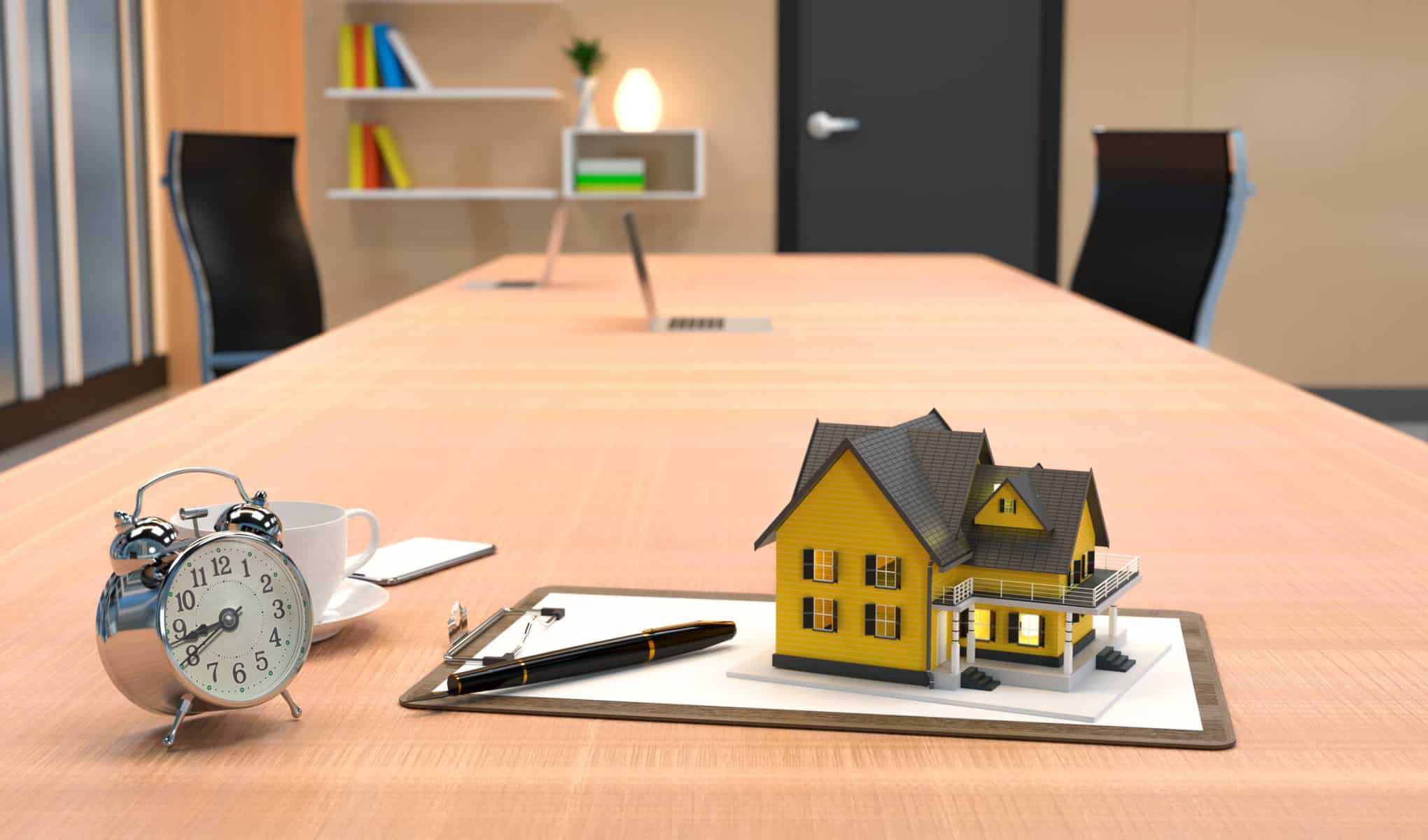 casa em cima de documentos e um relógio numa secretária a ilustrar quanto tempo demora a fazer um crédito habitação