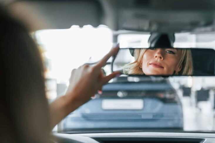 mulher no carro a olhar para o retrovisor