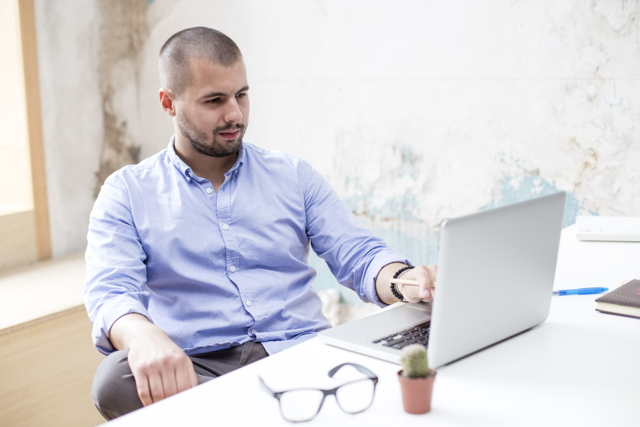 Jovem trabalhador a fazer o pedido no computador do prémio salarial de valorização das qualificações
