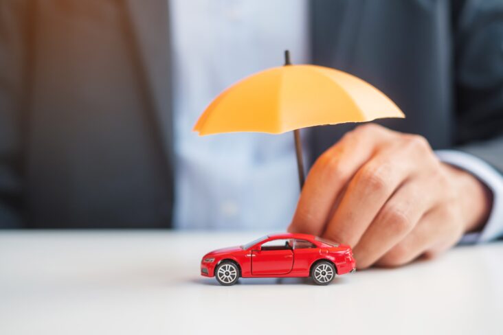 participação de acidente automóvel ilustrada com uma mão que segura um chapéu de chuva grande e amarelo, protegendo um carro de brincar, vermelho