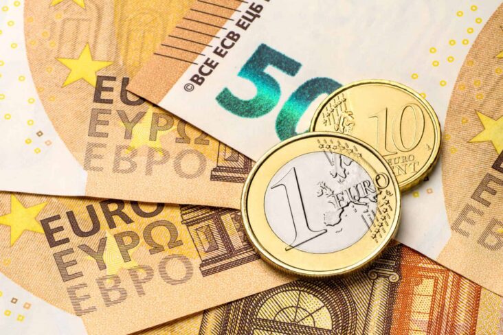 Uma moeda de um euro e outra de 20 cêntimos em cima de notas de 50 euros