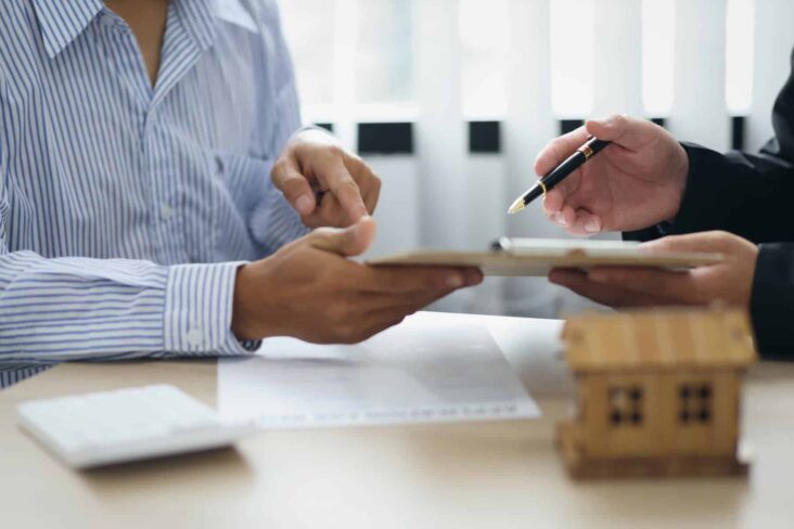 duas pessoas a olhar para as condições contratuais para perceber se é possível remover produtos associados ao crédito habitação