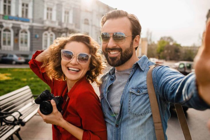 casal de férias feliz após saber que erros não deve cometer este ano