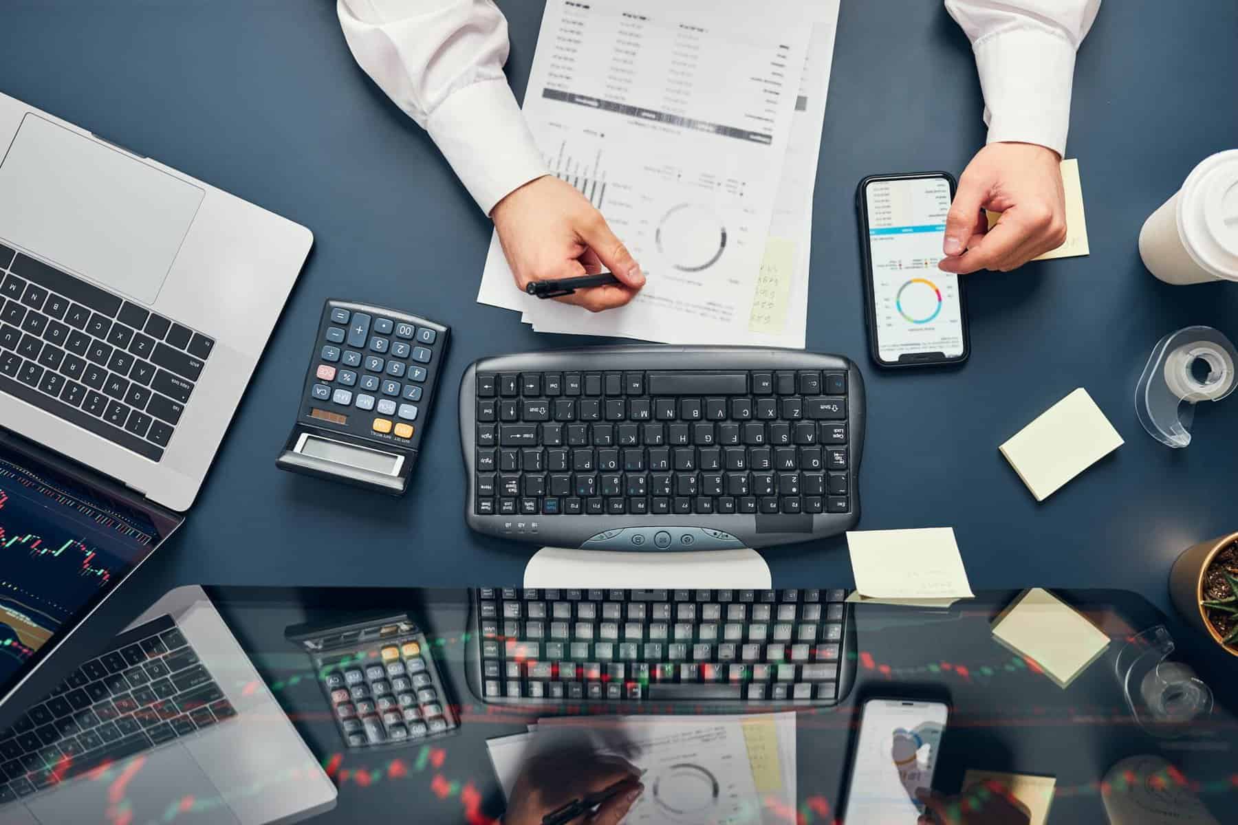 investidor a usar computador e smartphone para investir em ações