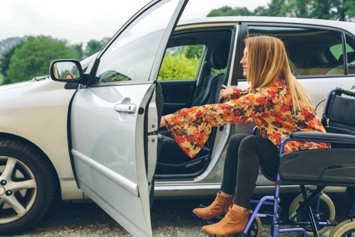 Mulher em cadeira de rodas a entrar no carro