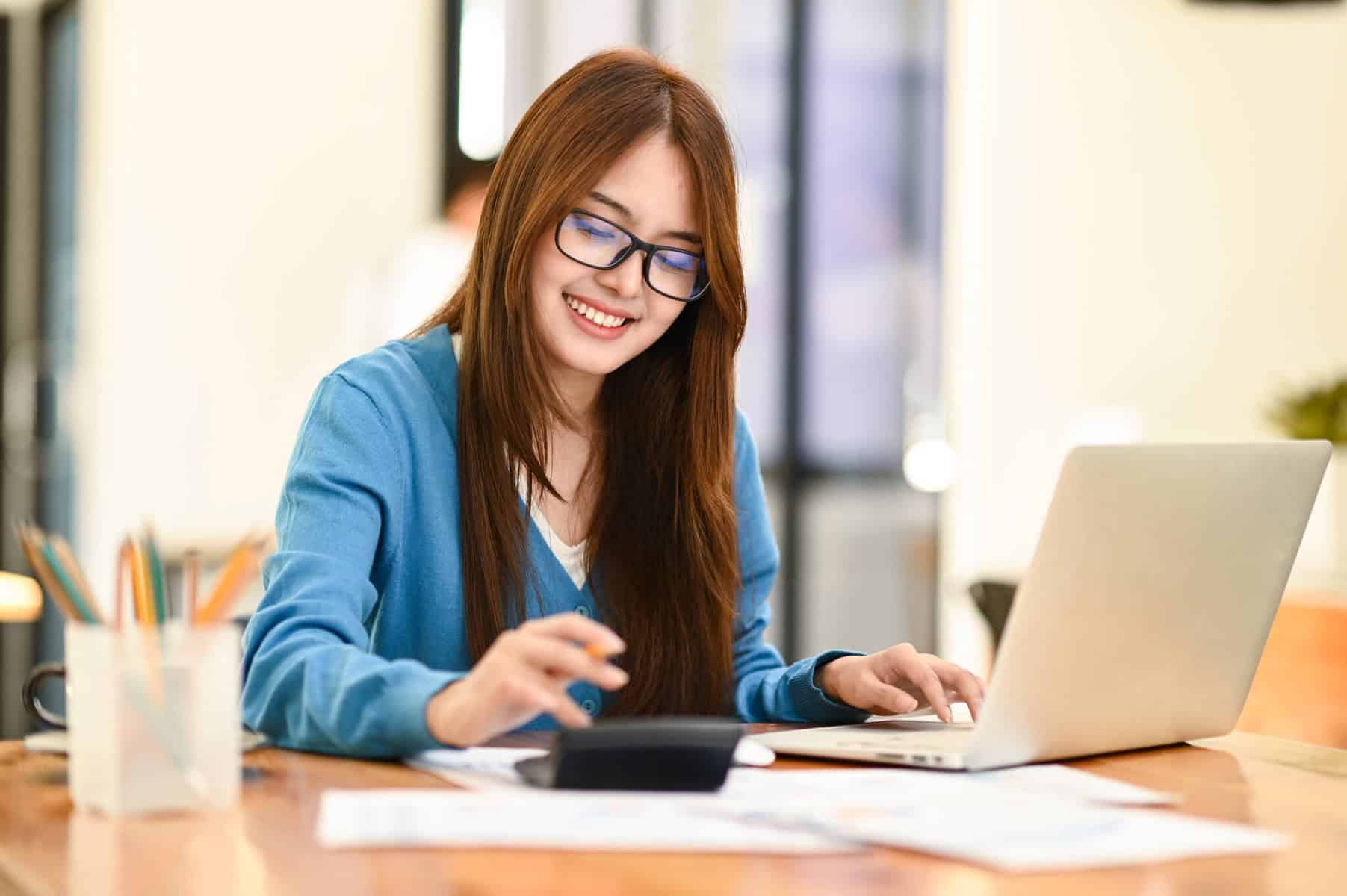mulher a fazer contas na calculadora para conseguir renegociar um crédito pessoal