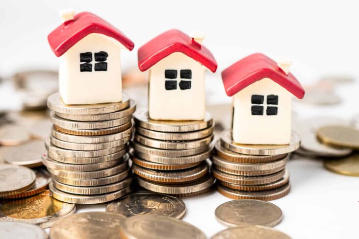 imagem de casas em miniatura em cima de moedas - alusão aos dados do BdP sobre crédito habitação - sobre o spread abaixo de 1%