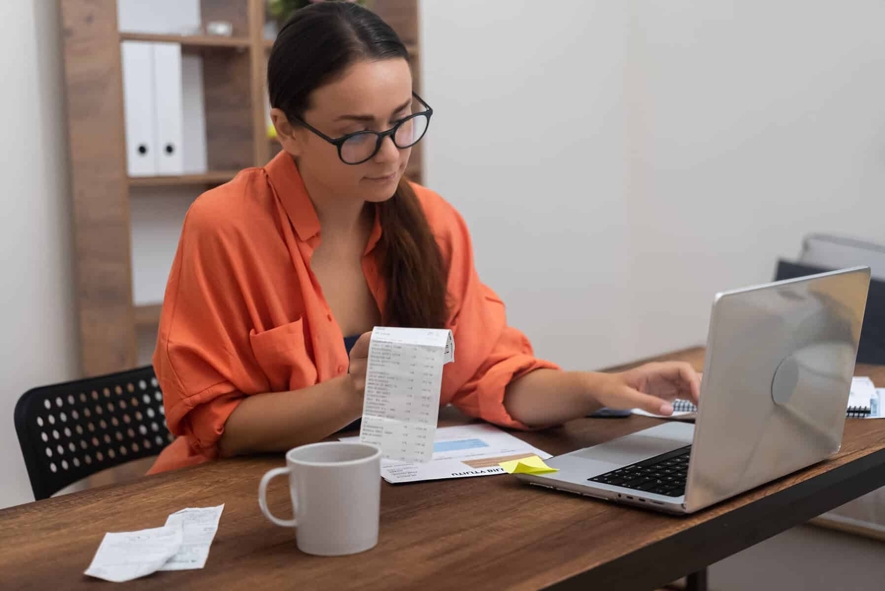 Jovem mulher faz contas às despesas que tem, avaliando a sua capacidade de pagar as suas contas e percebendo se recorrer a um crédito pessoal é uma solução